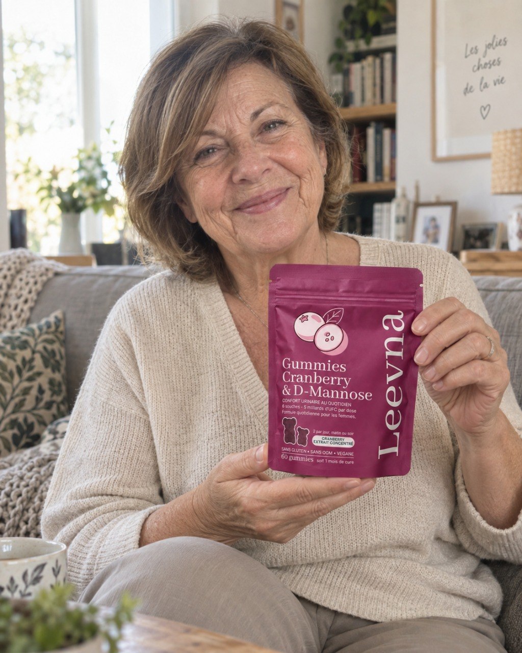 Une femme présente son pack de gummies Leevna à la cranberry